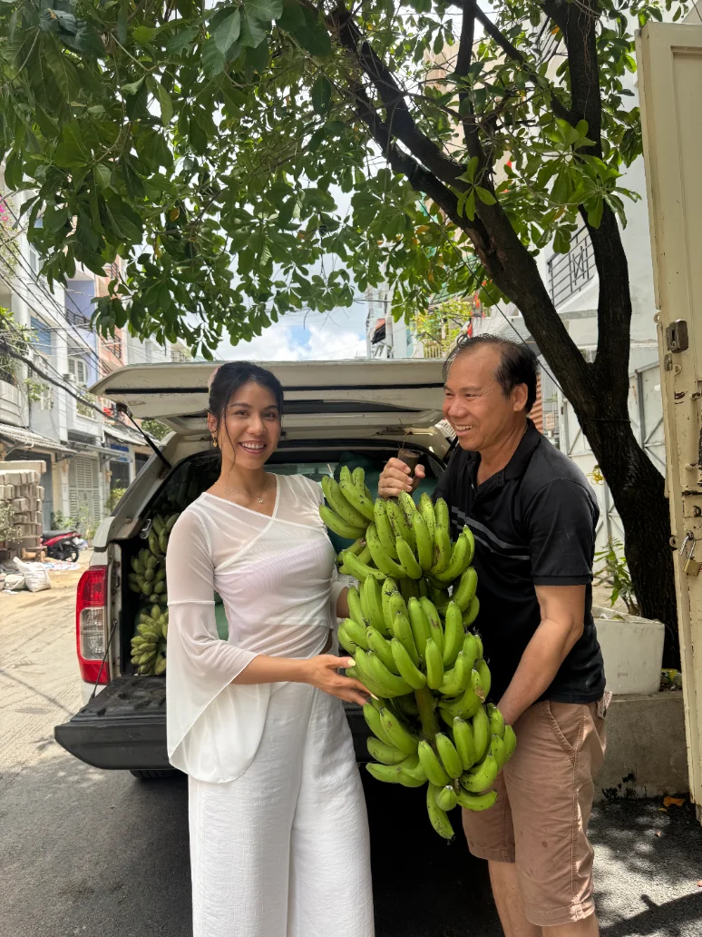 Vy and her dad with a bunch of bananas from the farm